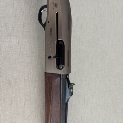Espingarda Beretta com cabo em madeira e corpo metálico cor bronze