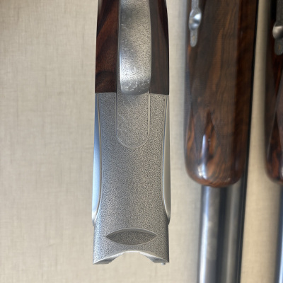 Parte superior de arma de fogo com metal gravado e madeira castanha polida