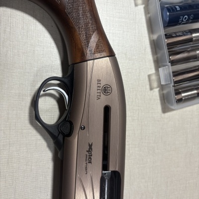 Espingarda Beretta Xplor Action com punho em madeira e caixa plástica com peças metálicas.