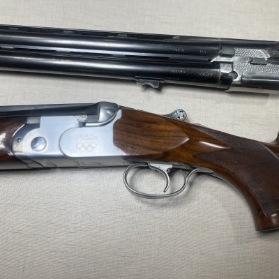 Espingarda de caça dupla desmontada com coronha de madeira e caixa metálica prateada