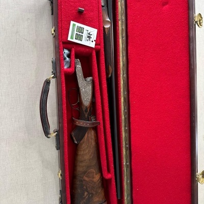 Estojo aberto com espingarda e caixa pequena dentro