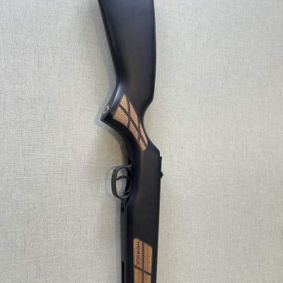 Espingarda preta com detalhes castanhos texturizados sobre fundo claro