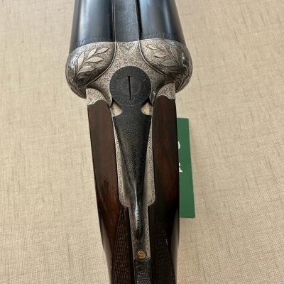 Espingarda dupla com detalhes gravados e coronha de madeira escura