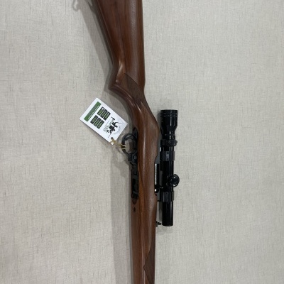 Carabina de madeira castanha com mira telescópica preta e etiqueta pendurada