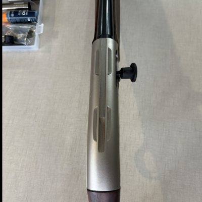 Espingarda com coronha em madeira escura e cano metálico preto