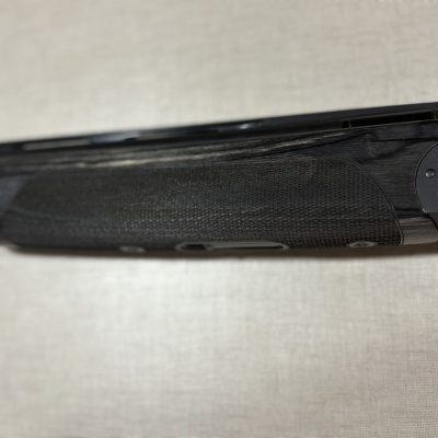 Arma de fogo com cabo de madeira escura e corpo metálico preto