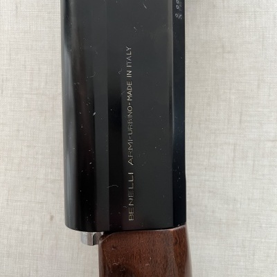 Arma de fogo preta com empunhadura de madeira e gravação BENELLI ARMI-URBINO-MADE IN ITALY