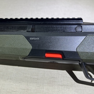 Arma de fogo preta e verde com detalhe vermelho e texto BRNO