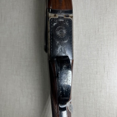 Espingarda de cano duplo com detalhes em metal gravado e coronha de madeira