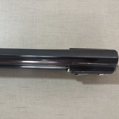 Parte superior preta brilhante de arma sobre superfície cinza clara