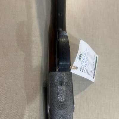 Espingarda de caça com detalhes metálicos gravados e etiqueta branca