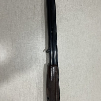 Espingarda de canos paralelos de metal azul escuro e madeira castanha escura