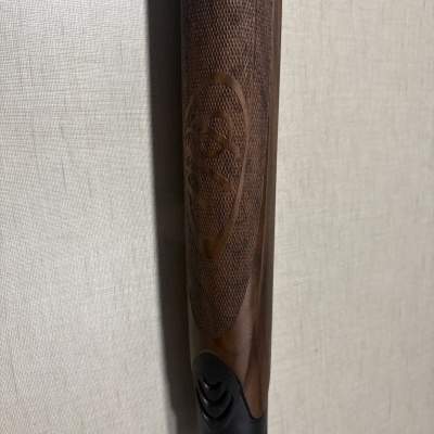 Coronha de espingarda em madeira escura com gravação e acabamento preto