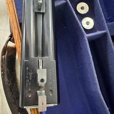 caçadeira de canos duplos em caixa de veludo azul com dois cartuchos metálicos