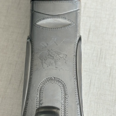 Gravação decorativa em metal e madeira de arma com figura de índio a cavalo