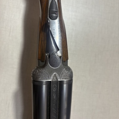 Espingarda dupla de metal e madeira, com gravações florais, número 074A e marca BERETTA.