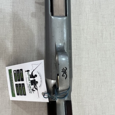 Fuzil com acabamento metálico e madeira escura, etiqueta branca com texto SPORTARGO e logo