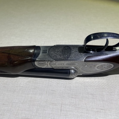 Espingarda de cano duplo com detalhes em madeira e metal gravado