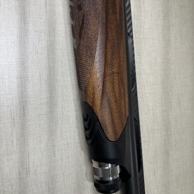 Coroha de arma de fogo em madeira castanha com metálico preto e anel prateado