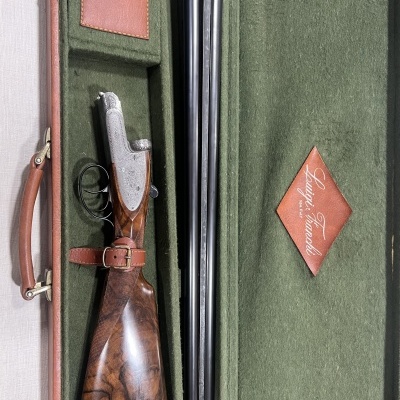 Espingarda de canos duplos com coronha em madeira dentro de estojo verde almofadado com etiqueta 'Luigi Fausti'