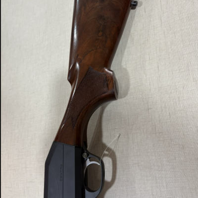 Espingarda com coronha em madeira castanha e caixa preta com a palavra CENTRO