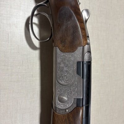 Espingarda de madeira e metal com detalhes gravados, gatilho duplo e texto BERETTA no cano