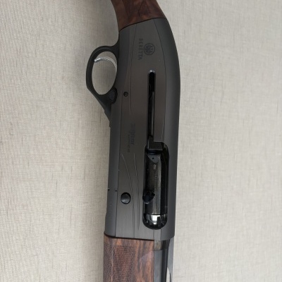 Espingarda Beretta com coronha em madeira castanha e corpo em metal preto fosco