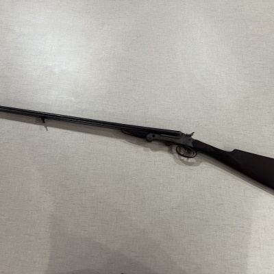 Espingarda de cano duplo com coronha em madeira escura e canos metálicos negros