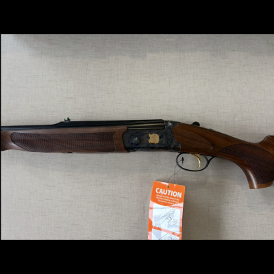 Espingarda dupla com coronha de madeira castanha e etiqueta de segurança laranja