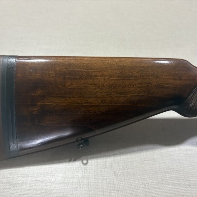 Coronha de rifle em madeira polida castanha com patilha de borracha e suporte de correia metálico