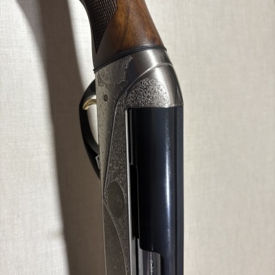 Espingarda com madeira castanha, metal prateado com gravuras e cano preto