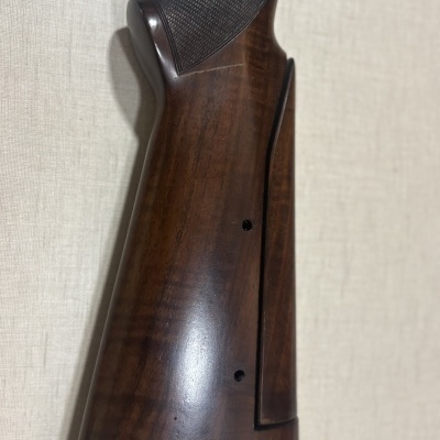 Coronha de arma de madeira escura com relevo preto