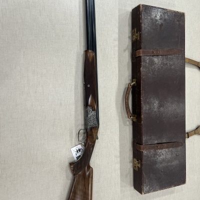 Espingarda com coronha de madeira e estojo castanho sobre fundo claro