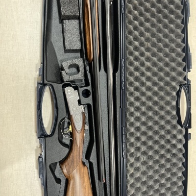 Estojo preto com espingarda desmontada em madeira e metal