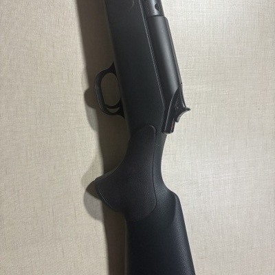 Arma de fogo preta com empunhadura em material sintético e gatilho