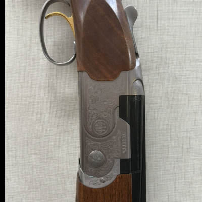 Espingarda de sobrepor com madeira castanha, gatilho dourado, armação cinzenta com gravações e cano preto