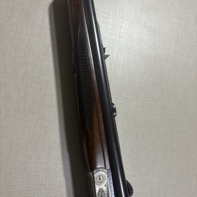 Espingarda com coronha de madeira castanha e detalhes metálicos gravados