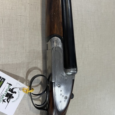 Espingarda de canos duplos com detalhes em metal prateado e madeira escura