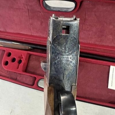 Espingarda com detalhes em madeira e metal gravado sobre estojo vermelho de veludo