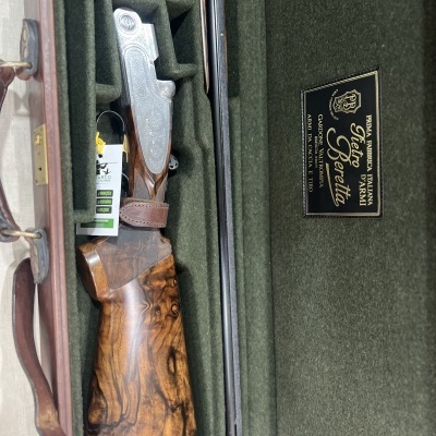 Espingarda de caça Beretta em estojo verde com detalhe em madeira e metal.