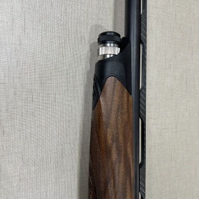 Arma de fogo com coronha de madeira e componente metálico preto e prateado