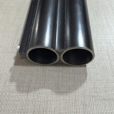 Cano duplo metálico preto sobre tecido bege