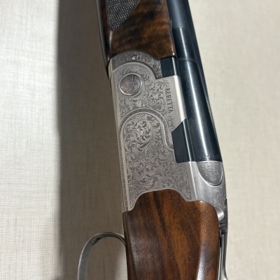 Espingarda Beretta com detalhes gravados e coronha de madeira castanha