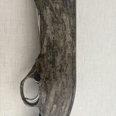 Arma de fogo camuflada com texto e gatilho