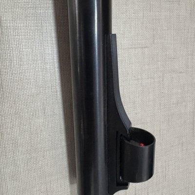 Detalhe de arma de fogo preta com parte do cano e suporte