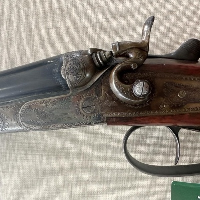 Espingarda de canos duplos com gravações e empunhadura de madeira