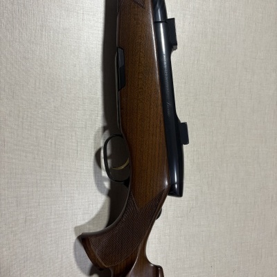 Carabina em metal preto com empunhadura em madeira castanho escuro