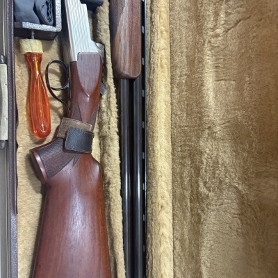 Espingarda de caça em mala forrada de pelúcia bege com ferramenta de cabo laranja