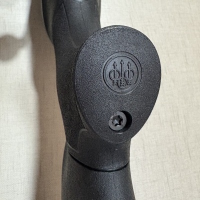 Parte da arma preta com logótipo Beretta e textura áspera