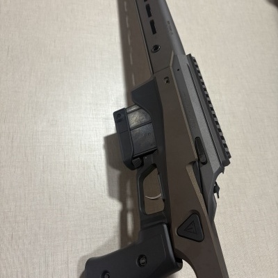 Rifle semi-automático com acabamento metal e plástico preto, punho ergonómico e trilho para acessórios.